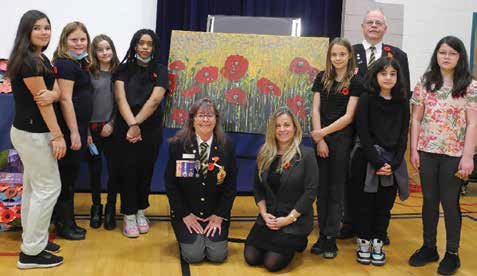 At its Remembrance Day assembly, Lady Evelyn Alternative School students were presented with a painting honouring Corporal Nathan Cirillo. From left: Stella Kager, Saralyn Sheppard, Mollie Giesbrecht, Bethlehem Wondimagnehu, Comrade Wanda Riddell, Principal Kimberly Esdaile, Raya Duncan, Comrade Robin Brown, Rawan El-Barghoti, Calliope Carroll. Photo by John Dance