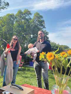Chris Galbraith, Olivia Crossman and their daughter Audrey taking in the art tour on Echo Drive under blue skies and amongst fall flowers. Photo by Tanis Browning-Shelp